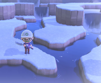 AC: waterfalls1 My character is wearing a t-shirt, red pants, glasses, construction hat, and green moustache, and stands holding a shovel in front of a branching narrow waterway with waterfalls falling down layered cliffs. The ground is snowy and everything is a bit blocky.